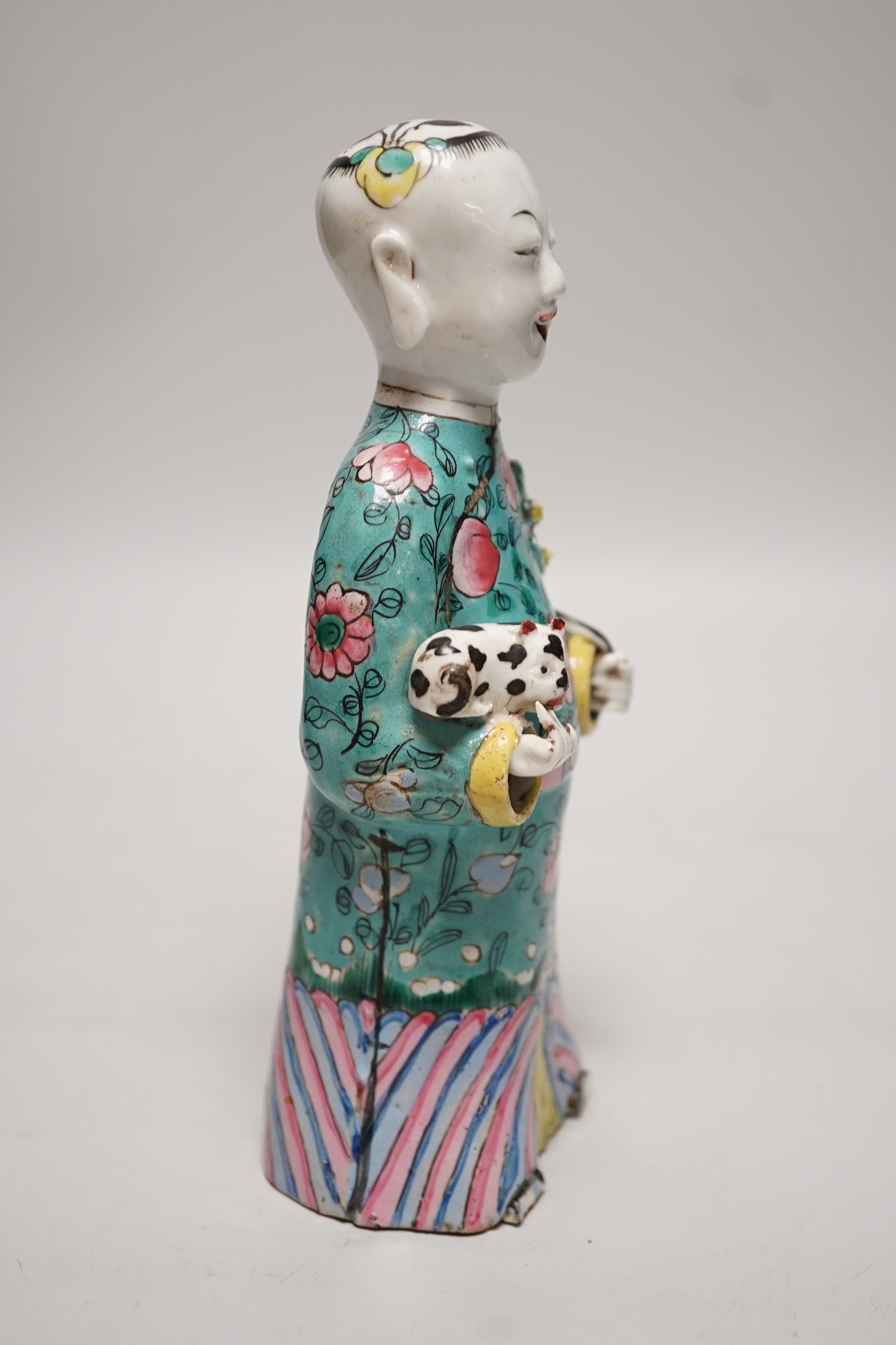 An early 19th century Chinese enamelled porcelain figure of a boy holding a cat and a sprig of prunus, 20cm